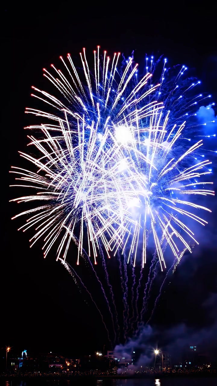 Vibrant Fireworks Bursting Over a City at Night