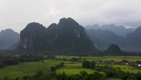 vista panorámica de los campos de vang vieng con montañas en el fondo