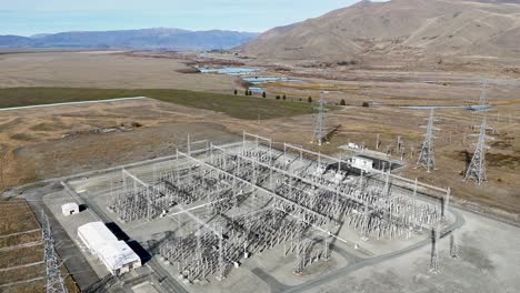 drone footage captures an expansive power substation in lake tekapo, new zealand, surrounded by rugged landscapes under clear skies