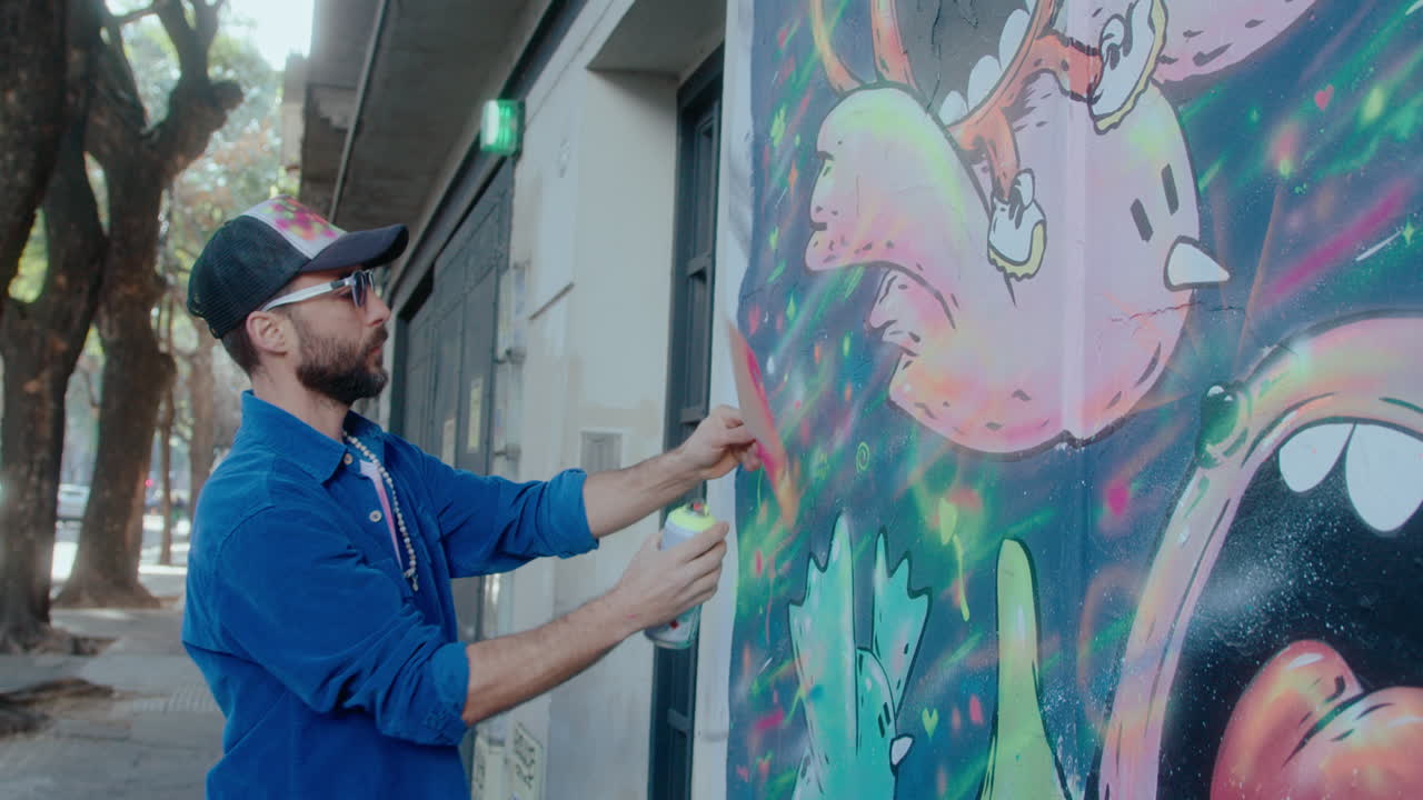 Graffiti Artist Drawing on Street Wall with Spray Paint and Paper Template