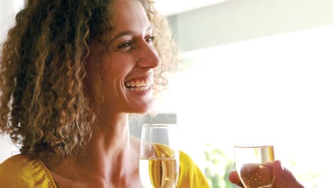 Cute-couple-toasting-with-champagne-in-the-living-room