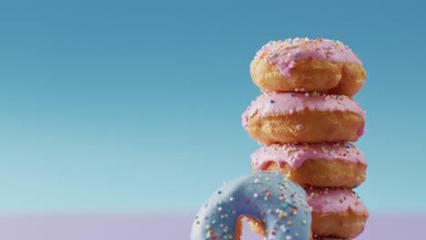 video of donuts with icing on pink and blue background