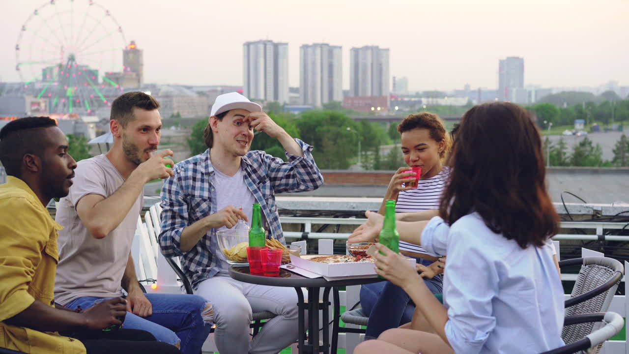 Friends Enjoying Rooftop Pizza and Beer