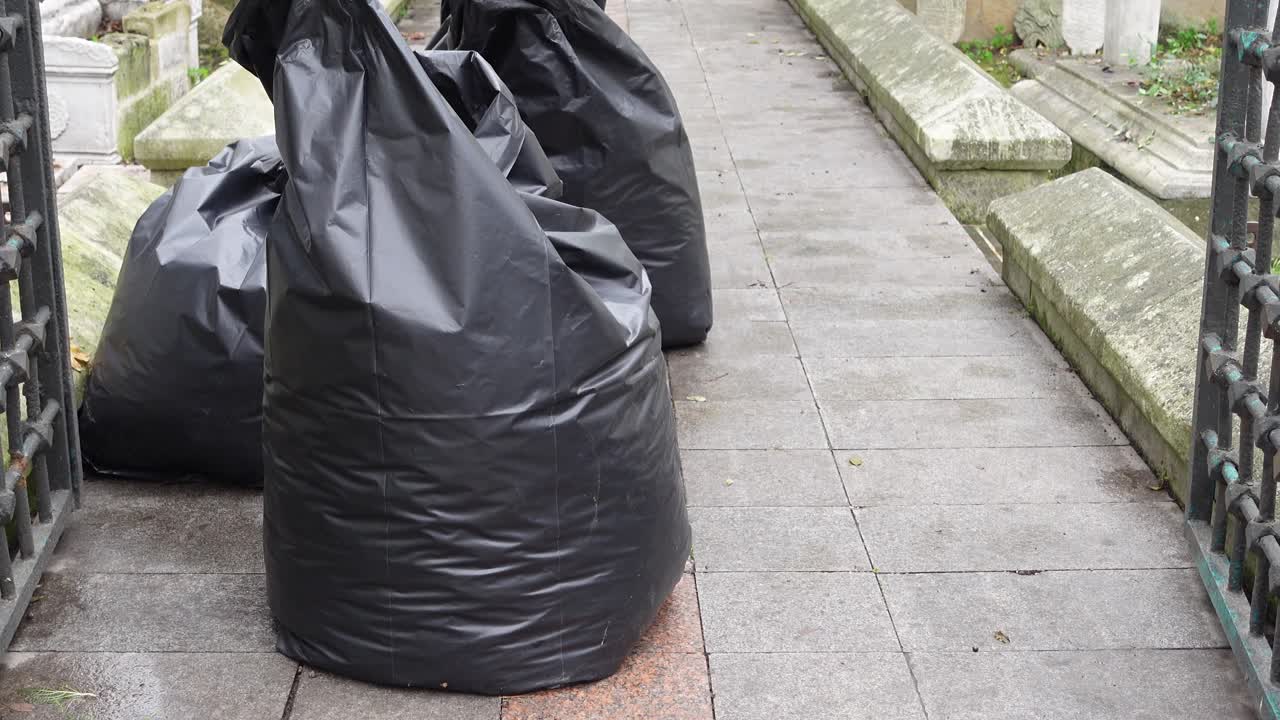 Sacchi dei rifiuti su sentiero del cimitero