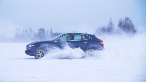 suv azul conduciendo a través de la nieve profunda