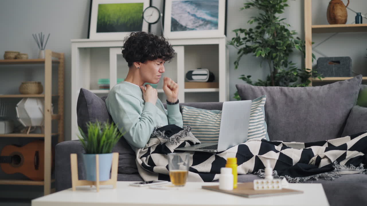 Sick Person on Couch with Laptop
