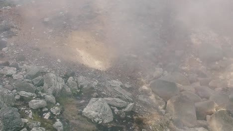 formación geotérmica burbujeante activa con vapor que se eleva desde el géiser gris de aguas termales, bandeja de cierre
