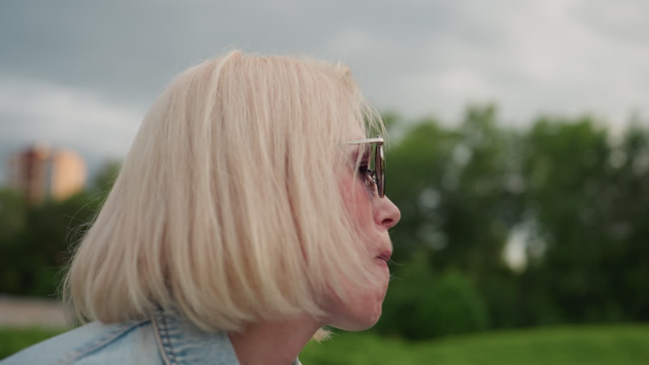mom and kid at picnic in park, child offering pear while seated mother bites fruit, warm summer light on green grass, casual relaxed family moment of sharing and bonding