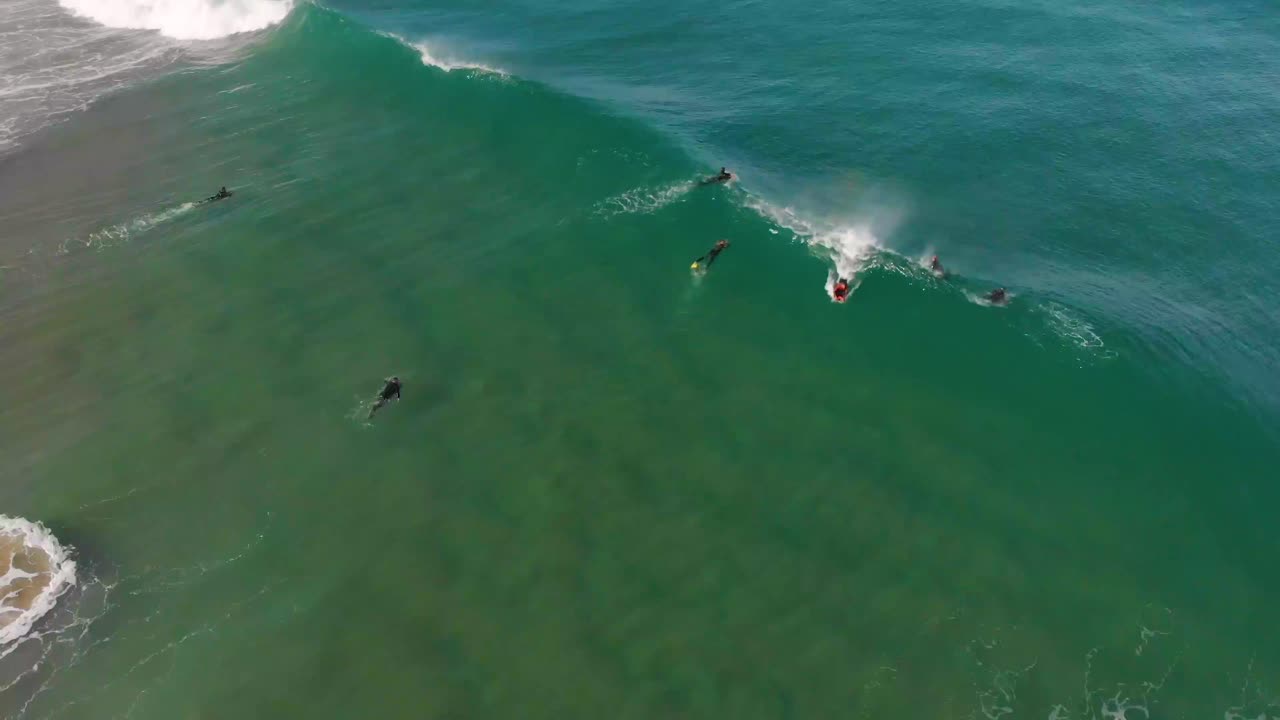 Bodyboarder che cavalca un'onda oceanica in una soleggiata giornata invernale.