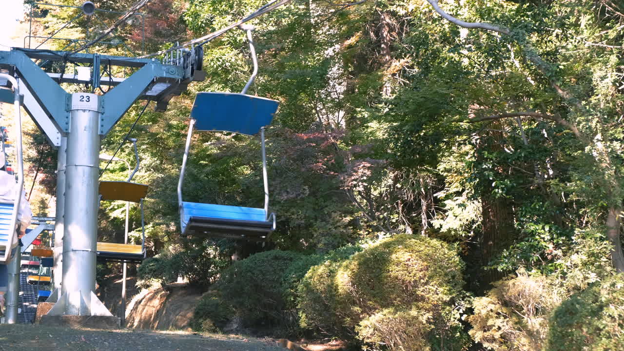Stolelifte kører op mellem træer i Takaomachi, Japan
