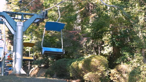 Sessellifte-Fahren-Zwischen-Bäumen-In-Takaomachi,-Japan-Nach-Oben