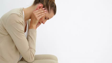 Desperate-ponytailed-woman-sitting-with-her-head-in-her-hands