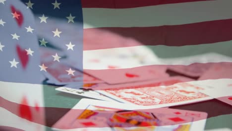 animation of playing cards falling over american flag waving
