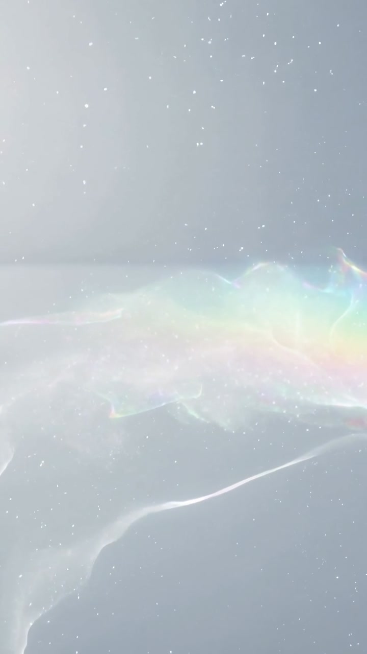 Vertical video: Shifting pearlescent wave, iridescent rainbow band rippling in studio, light moving