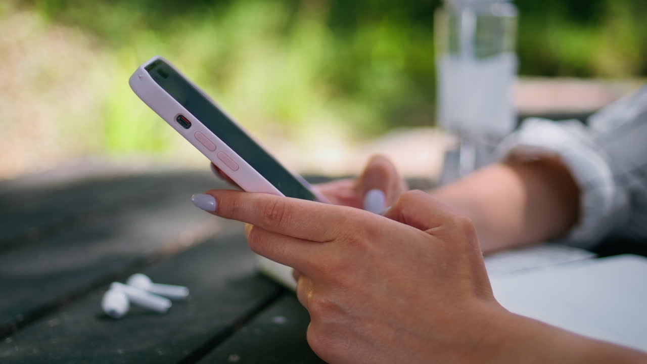 manos de mujer escribiendo teléfono móvil en la naturaleza de cerca. chica no reconocida enviando mensajes de texto