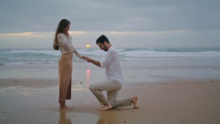Amorous lovers engaging sunset seashore. Handsome man making surprise proposal