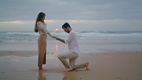 amorous lovers engaging sunset seashore. handsome man making surprise proposal