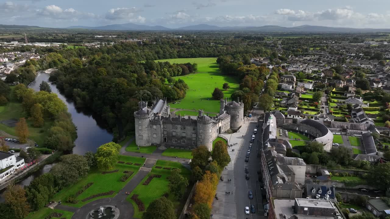 Kilkenny Castle, County Kilkenny, Ireland, September 2023. Drone orbits across the elegant formal gardens towards the River Nore with the Blackstairs Mountains of County Carlow in the distance.