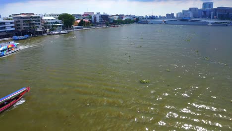 barco de cola larga y ferry en el río chao phraya con vista al puente somdet phra pinklao en bangkok, tailandia