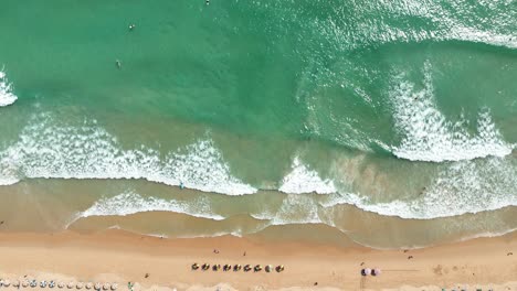 aerial view of a tropical beach with waves and people
