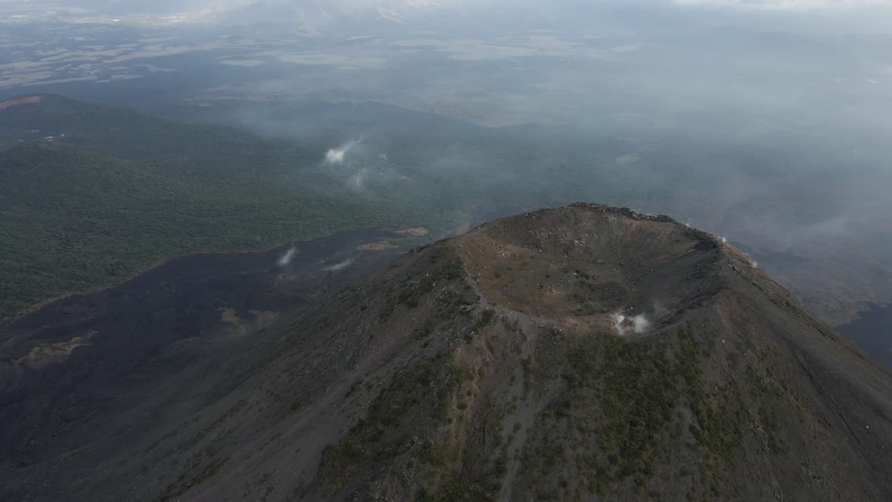 imágenes de drones del volcán izalco en el salvador con terreno volcánico accidentado bajo cielos nublados