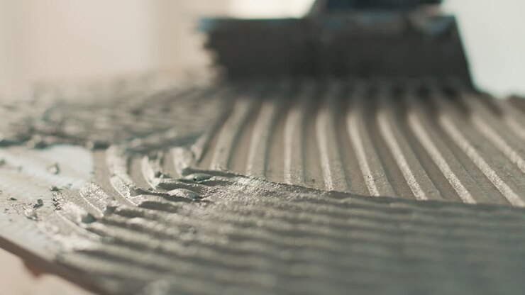 Spreading tile adhesive with a notched trowel