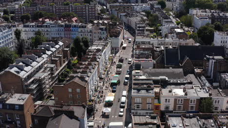 Descending-footage-of-street-with-market.-Row-of-tents-with-sellers-on-side-of-road.-Tilt-up-revealing-horizon.--London,-UK