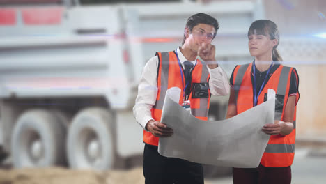 two caucasian workers wearing an orange high vest checking their plan and pointing fingers over rays