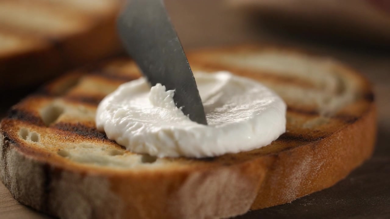 Spreading Cream Cheese on Toasted Bread Slice