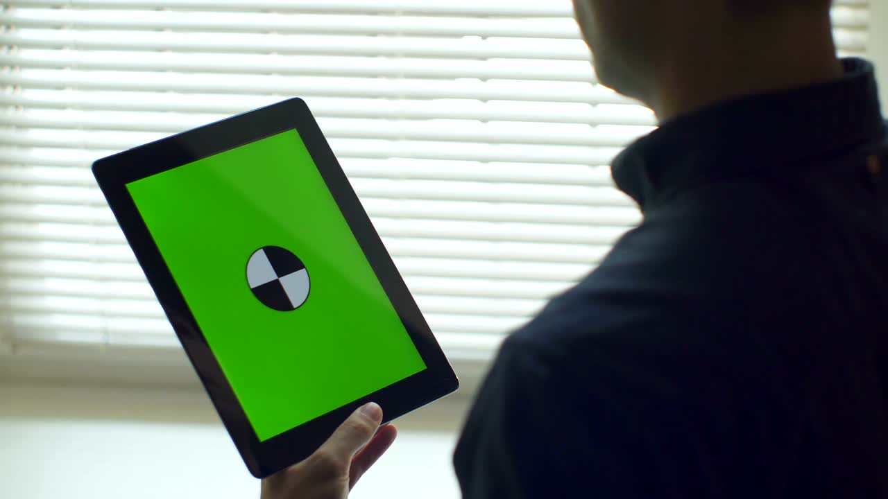 Uomo che usa un tablet. Tablet con schermo verde