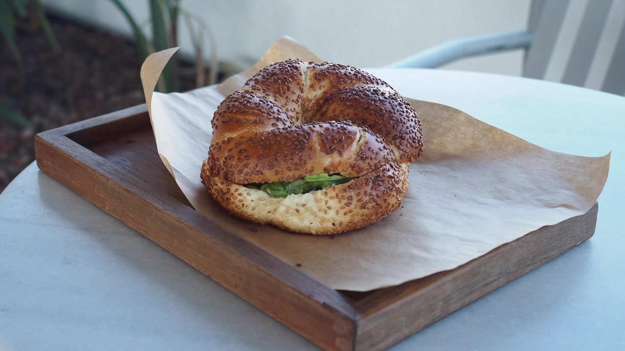 Simit fresco farcito con semi di sesamo su un vassoio di legno