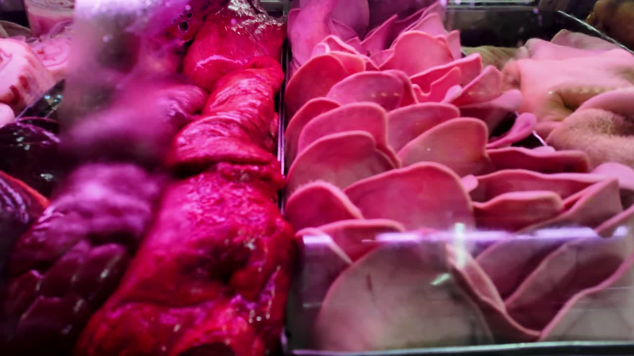 Close up Fresh pork cuts and organs displayed at a butcher's counter