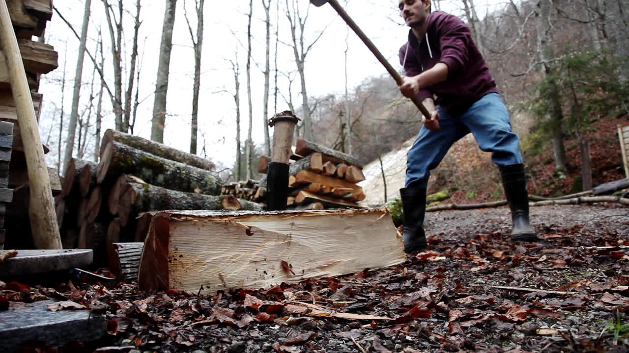 Lumberjack hammering axe at Swiss alps cottage