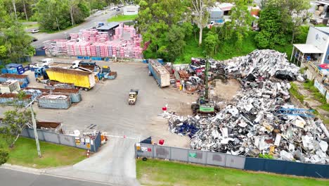 machines moving scrap metal in industrial yard