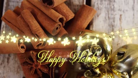 Animation-of-text,-happy-holidays,-in-yellow,-over-string-lights,-decorations-and-cinnamon-sticks