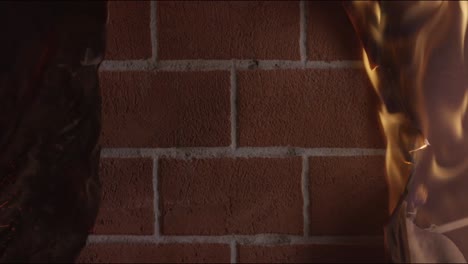 papel en llamas contra una pared de ladrillo