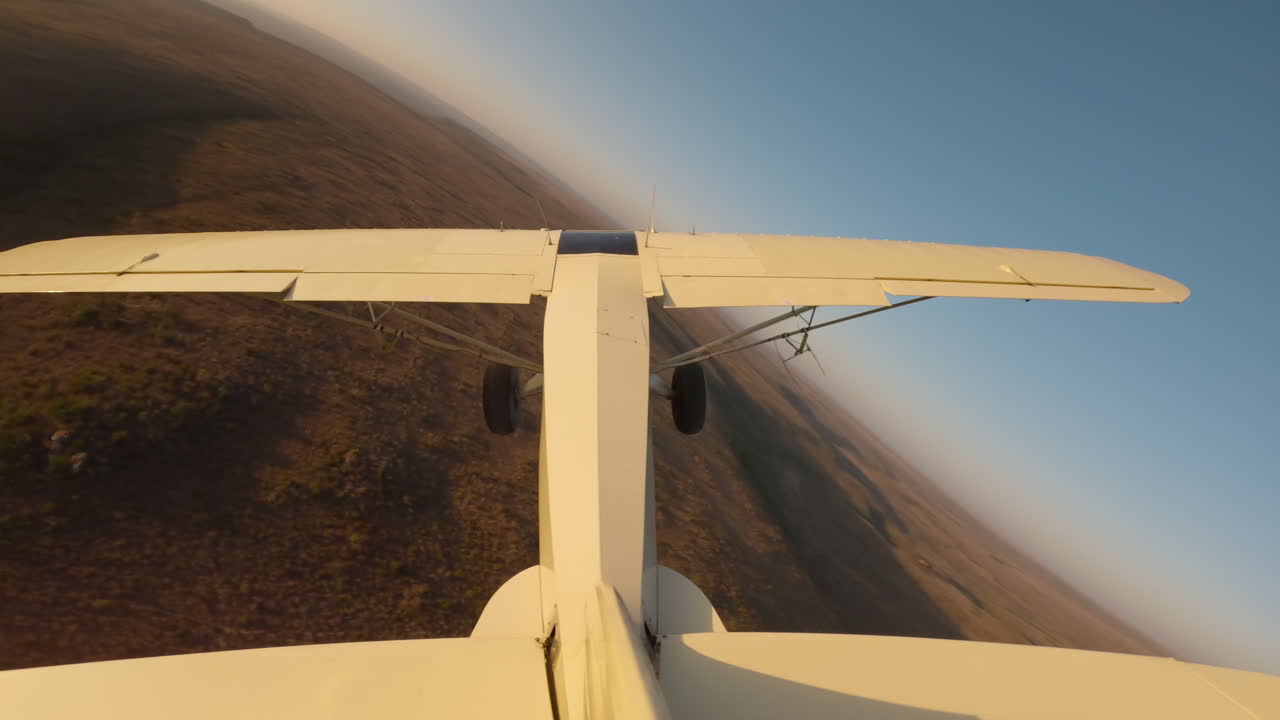 Bushcraft plane flying over a river hills at sunrise
