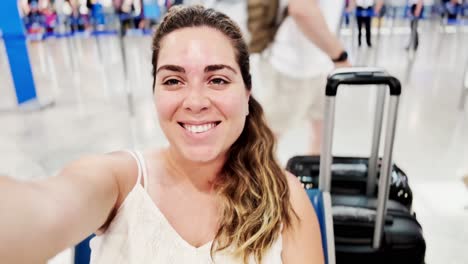 smiling woman with suitcase at airport gate waiting area