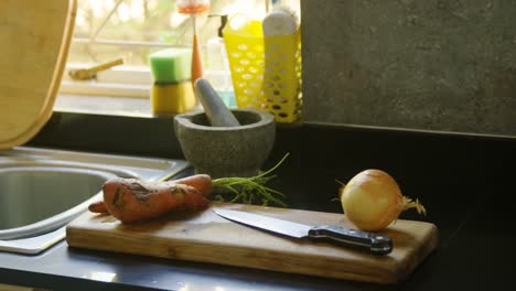 cebolla, zanahoria y batata dulce con cuchillo en la cocina 4k