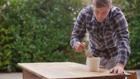 painting a wooden table outdoors