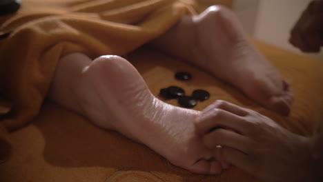 masaje de pies con piedras calientes en el spa diurno