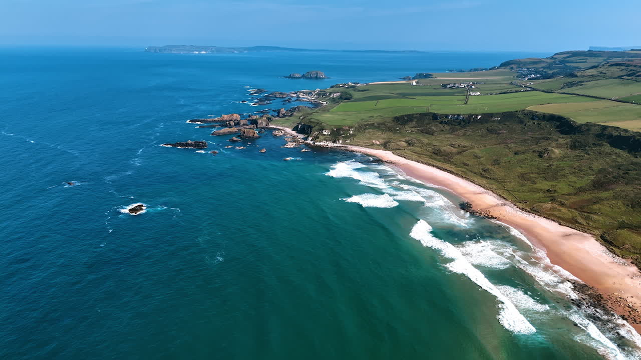 Rocky shore of Ireland at the waterscape of the Atlantic Ocean. Beautiful scenery of the coastline from top perspective on sunny day.
