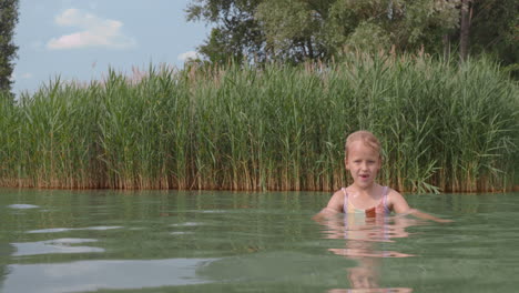 niña nadando en un cuerpo de agua natural