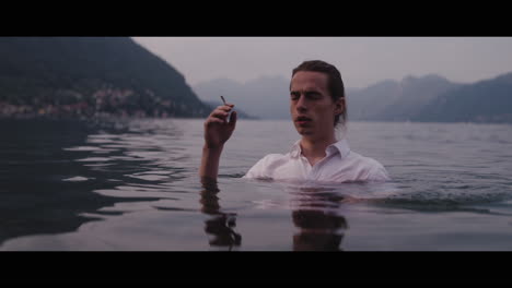 man smoking by a lake