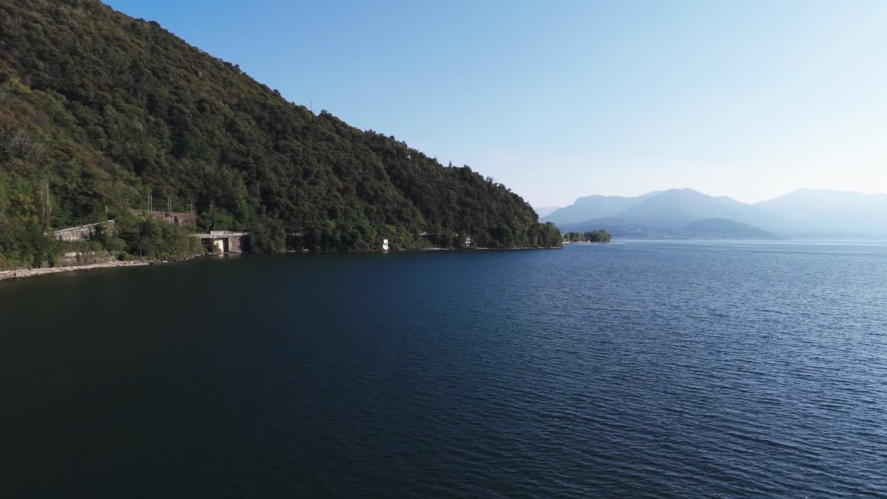 Fly over Lake Maggiore next to land, Italy