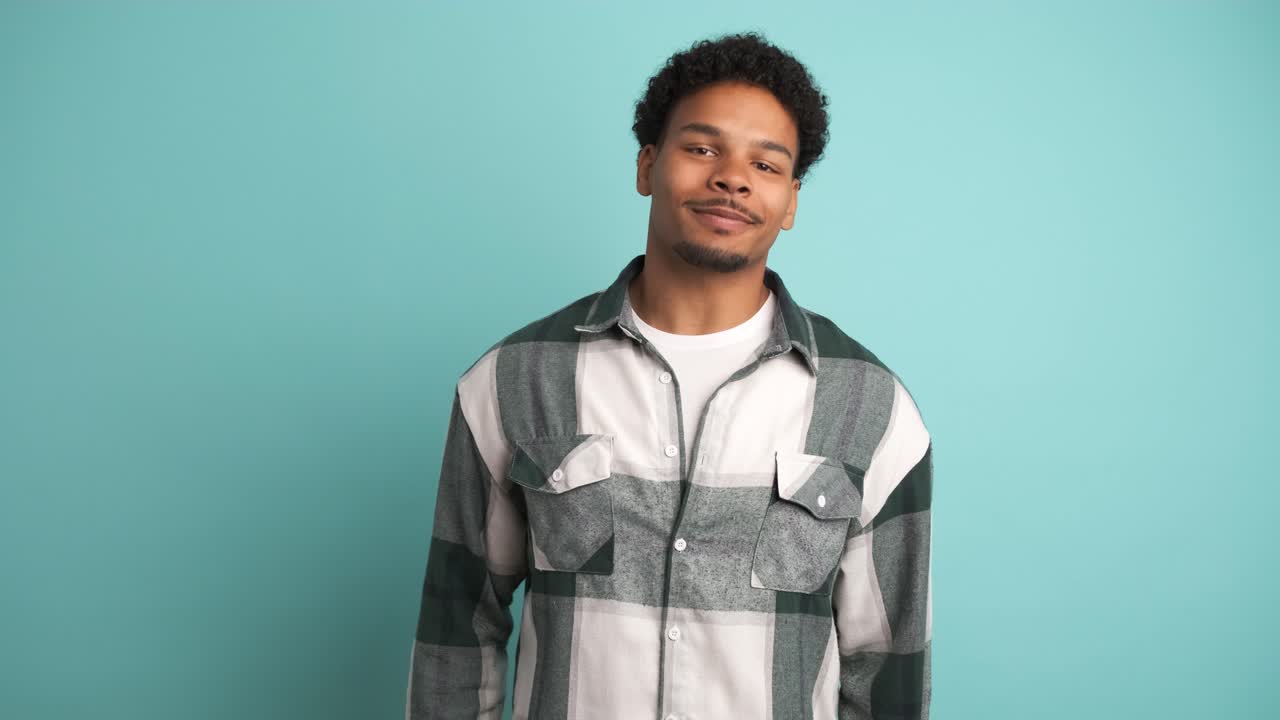 Happy young man in shirt looking at camera