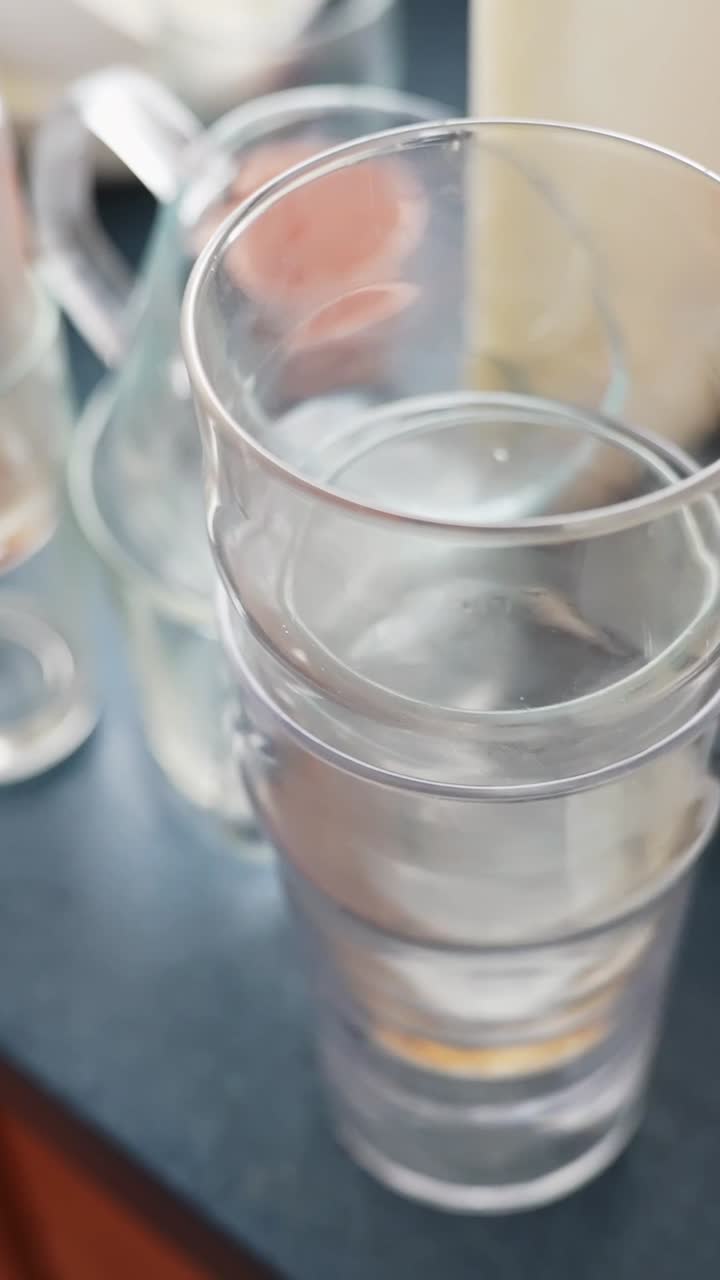 Bicchieri sporchi di cioccolato impilati vicino al lavandino, pronti per essere lavati. Vere faccende domestiche, routine dei piatti sporchi e concetto di disordine in cucina. Roll di repertorio verticale in primo piano