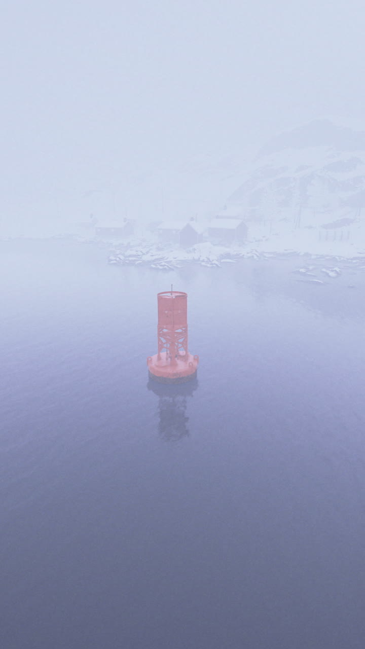 Foggy winter view of navigational buoy in cold waters