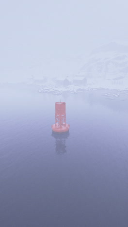foggy winter view of navigational buoy in cold waters