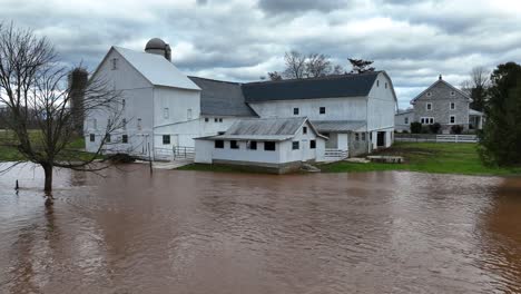 flooding fields surrounding farm house during cloudy day in usa